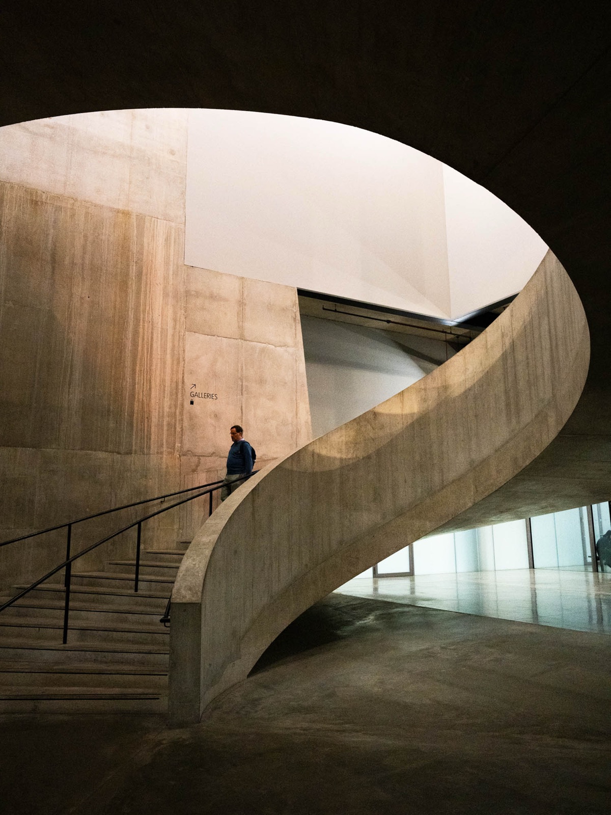Concrete spiral staircase, a visitor on the way down